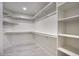 A spacious walk-in closet features shelving and hanging rods providing ample storage and organization solutions at 11566 E Christmas Cholla Dr, Scottsdale, AZ 85255