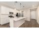 Modern kitchen with white cabinets, island, and stainless steel appliances at 17841 W Blue Sky Dr, Surprise, AZ 85387