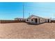 A backyard view of the home with a covered patio and an expansive, unfinished yard at 12314 W Marguerite Ave, Avondale, AZ 85323