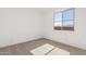 Minimalist bedroom featuring plush carpeting, large window offering abundant light, and a calming, neutral palette at 12314 W Marguerite Ave, Avondale, AZ 85323