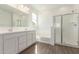 Bright bathroom featuring a double sink vanity, a separate tub, and a glass-enclosed shower at 12330 W Marguerite Ave, Avondale, AZ 85323