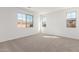 Bright, carpeted bedroom with a neutral palette boasts generous natural light from multiple windows at 12330 W Marguerite Ave, Avondale, AZ 85323