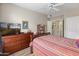 Cozy bedroom with a wooden dresser, TV, and a comfy bed with red and white striped bedding at 14950 W Mountain View Blvd # 1208, Surprise, AZ 85374