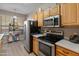 Galley-style kitchen with stainless steel appliances and light wood cabinets offers lots of counterspace at 14950 W Mountain View Blvd # 1208, Surprise, AZ 85374