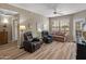 Spacious living room with two leather recliners, couch, ceiling fan, and a sliding glass door at 14950 W Mountain View Blvd # 1208, Surprise, AZ 85374