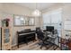 Bright office with a piano, large mirror, desk, rolling chair, and natural light at 14950 W Mountain View Blvd # 1208, Surprise, AZ 85374