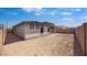 A large backyard has a covered patio and is enclosed by a block fence at 25118 N 171St Ln, Surprise, AZ 85387