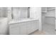 Contemporary bathroom featuring a dual sink vanity and an open doorway to a walk-in closet at 25118 N 171St Ln, Surprise, AZ 85387