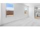 Sunlit bedroom featuring two windows, neutral carpet, and an open doorway to the Primary bathroom at 25118 N 171St Ln, Surprise, AZ 85387