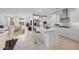 Modern white kitchen boasts a center island, stainless steel appliances, and opens to the living area at 25118 N 171St Ln, Surprise, AZ 85387