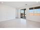 Bright, airy living room with white tile flooring, large windows, and sliding glass door to the backyard at 25206 N 172Nd Ln, Surprise, AZ 85387