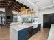 Open-concept living space with modern kitchen island, exposed beam ceiling, fireplace, and dining area at 3337 E Alexander Dr, San Tan Valley, AZ 85143