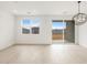 Bright, empty room featuring tile flooring, backyard access, and modern light fixture at 3337 E Alexander Dr, San Tan Valley, AZ 85143