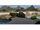 Backyard pool area with rock waterfall feature and desert landscaping against a mountain backdrop at 10270 E Saddle Horn E Trl, Scottsdale, AZ 85255