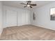 Bright bedroom with neutral carpeting, double door closet, and two windows at 1952 N 103Rd Dr, Avondale, AZ 85392