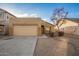 Tan one-story house with a two-car garage and mature trees at 1952 N 103Rd Dr, Avondale, AZ 85392