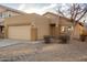 Tan one-story house with a two-car garage and desert landscaping at 1952 N 103Rd Dr, Avondale, AZ 85392