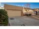 Tan house with a two-car garage and neutral landscaping at 1952 N 103Rd Dr, Avondale, AZ 85392