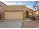 Tan house with a two-car garage and neutral landscaping at 1952 N 103Rd Dr, Avondale, AZ 85392