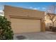 Tan house with a two-car garage and neutral landscaping at 1952 N 103Rd Dr, Avondale, AZ 85392