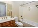 Bathroom featuring a tub shower, wood vanity, toilet, decorative mirror, and natural light at 42086 W Solitare Dr, Maricopa, AZ 85138