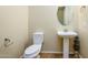 Powder room with pedestal sink, neutral walls, decorative mirror, and wood-look floors at 42086 W Solitare Dr, Maricopa, AZ 85138