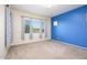 Bedroom with blue accent wall, neutral carpet, and window that fills the room with natural light at 42086 W Solitare Dr, Maricopa, AZ 85138