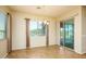 Bright dining room features wood-look tile floors, chandelier, window, and sliding glass door to the patio at 42086 W Solitare Dr, Maricopa, AZ 85138