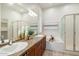 Bright bathroom featuring a granite-topped vanity with dual sinks and a separate soaking tub and shower at 10851 E Le Marche Dr, Scottsdale, AZ 85255