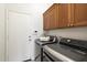 Laundry room with gray front-loading washer and dryer, plus cabinetry and access door at 10851 E Le Marche Dr, Scottsdale, AZ 85255