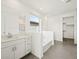 Bright bathroom showcasing a tub, walk-in closet, gray tile flooring and a dual sink vanity with a mirror at 3649 E Alexander Dr, San Tan Valley, AZ 85143