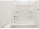 Bright, clean bathroom featuring a white shower-tub combo with built-in shelving at 3649 E Alexander Dr, San Tan Valley, AZ 85143