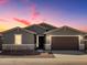 Charming single-story home with neutral paint, stone accents, and a two-car garage at dusk at 3649 E Alexander Dr, San Tan Valley, AZ 85143