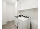 Well-lit laundry room with modern washer and dryer set and overhead shelving at 3649 E Alexander Dr, San Tan Valley, AZ 85143