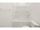 Clean bathroom with a shower/tub combo and built-in shelving at 36833 W La Paz St, Maricopa, AZ 85138