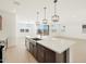 Open concept kitchen with island and modern light fixtures at 36833 W La Paz St, Maricopa, AZ 85138
