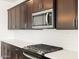 Modern kitchen with stainless steel appliances and dark brown cabinets at 36833 W La Paz St, Maricopa, AZ 85138