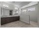 A spacious bathroom featuring double sinks, a large mirror, and a walk-in shower with tile surround at 19964 W Marshall Ave, Litchfield Park, AZ 85340