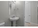 Clean, simple bathroom with pedestal sink, toilet, and door at 19964 W Marshall Ave, Litchfield Park, AZ 85340