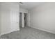 A carpeted bedroom featuring neutral walls, trim and doors, as well as a glimpse to an adjacent room at 19964 W Marshall Ave, Litchfield Park, AZ 85340