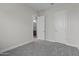 A carpeted bedroom featuring neutral walls, trim and doors, as well as a glimpse to an adjacent room at 19964 W Marshall Ave, Litchfield Park, AZ 85340