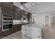 Modern kitchen featuring stainless steel appliances, custom cabinetry, and a large island with marble countertops at 19964 W Marshall Ave, Litchfield Park, AZ 85340