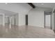 Bright, open-concept living room with high ceilings, wood beam, tile flooring, and sliding glass doors at 19964 W Marshall Ave, Litchfield Park, AZ 85340