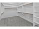 A carpeted walk-in closet with multiple levels of shelving and hanging rods, providing ample storage at 19964 W Marshall Ave, Litchfield Park, AZ 85340