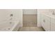 Bathroom with a bathtub and view into a carpeted bedroom at 37422 W San Clemente St, Maricopa, AZ 85138