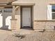 Front entry with white door and stone accents at 37422 W San Clemente St, Maricopa, AZ 85138