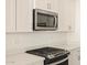 Modern kitchen with stainless steel appliances and white cabinetry at 37422 W San Clemente St, Maricopa, AZ 85138