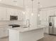 Modern kitchen featuring white cabinets, stainless steel appliances, and an island at 37422 W San Clemente St, Maricopa, AZ 85138