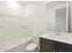 Bathroom with dark vanity, white sink and toilet, and a bathtub at 37501 W San Clemente St, Maricopa, AZ 85138