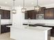 Modern kitchen with island, stainless steel appliances, and dark wood cabinetry at 37501 W San Clemente St, Maricopa, AZ 85138